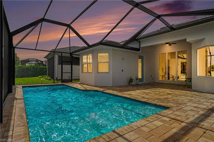 Screened pool enclosure featuring a rectangular pool and paver deck.