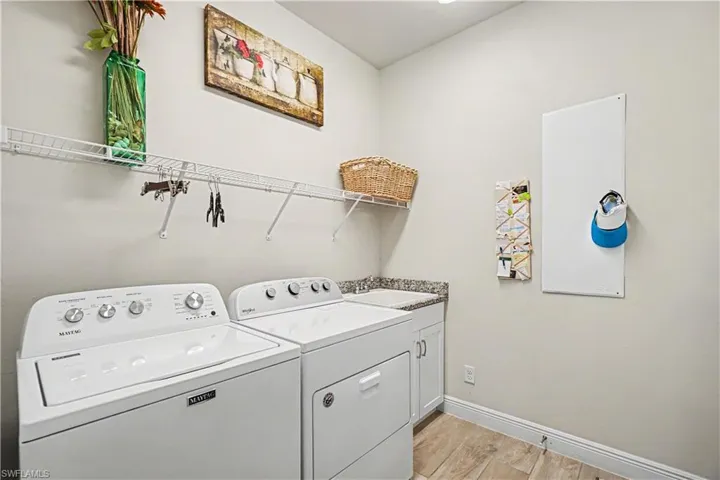 Laundry area featuring a built-in utility sink, cabinet storage, wire shelving.
