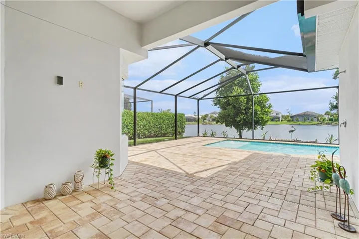 Screened-in outdoor living space with a paver patio and an in-ground swimming pool