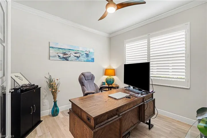 Crown molding,ceiling fan, and white  plantation shutters.