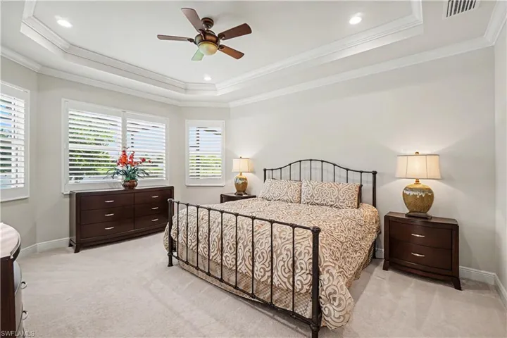Tray ceiling with recessed lighting and crown molding. His and her closets.