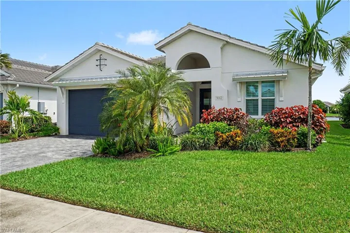 Tiled roof, paver driveway, and an arched entry.