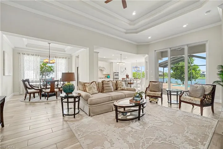 Spacious living area featuring coffered ceilings, recessed lighting, and large sliding glass doors
