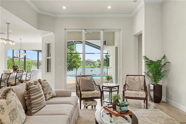 Sliding glass doors opening to an outdoor living space, crown molding, recessed lighting, and tile flooring.