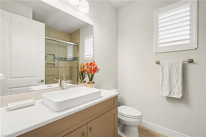 Vanity with a rectangular sink, brushed nickel faucet, and quartz countertop