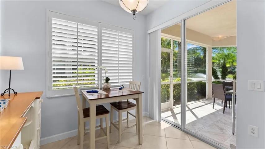 Tiled dining space featuring a healthy amount of sunlight