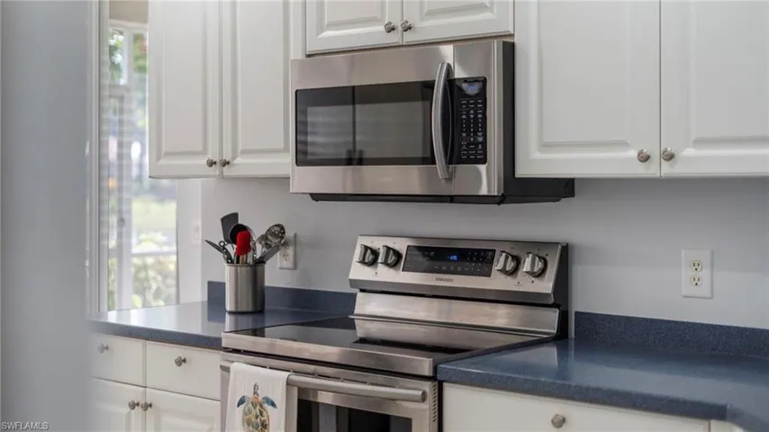 Kitchen with stainless steel appliances and white cabinetry