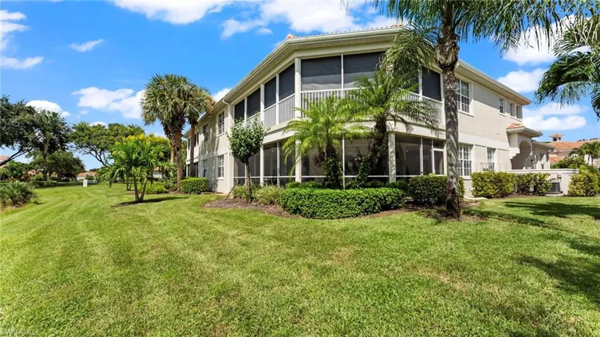 View of home's exterior with a lawn and a lanai