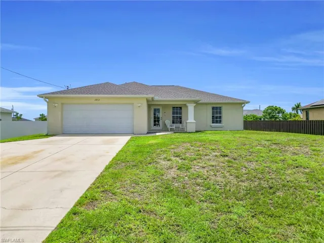 View of front of house featuring a garage, stucco siding, and driveway