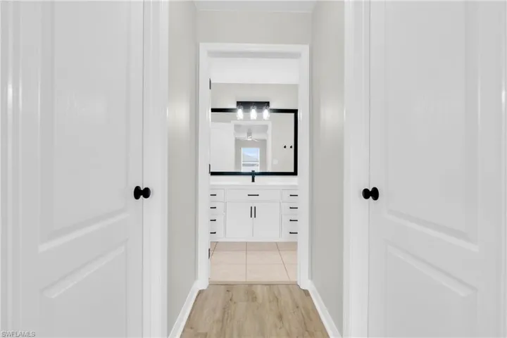Corridor with light wood-style flooring and baseboards