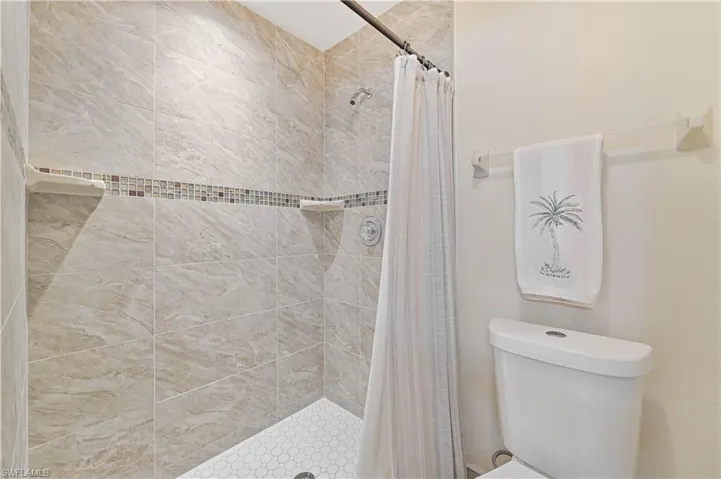 Bathroom featuring curtained shower and toilet