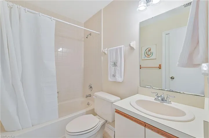 Full bathroom featuring shower / bath combo with shower curtain, tile patterned floors, toilet, and vanity