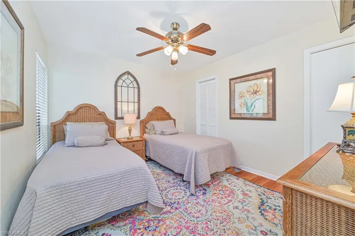 Bedroom featuring ceiling fan, wood-type flooring, and a closet