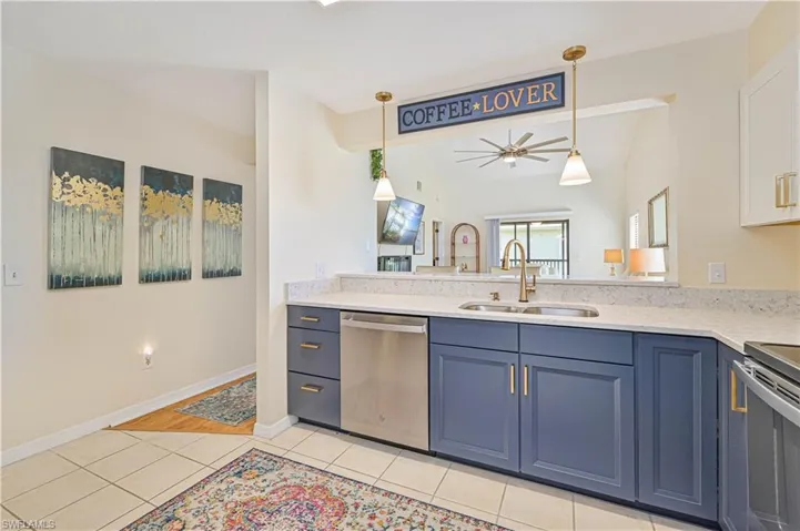 Kitchen with ceiling fan, sink, dishwasher, lofted ceiling, and light tile patterned floors