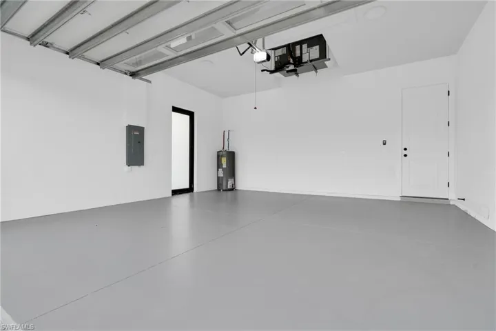 Garage featuring electric panel and electric water heater