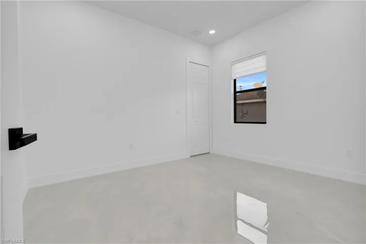 Bedroom (2) with finished concrete floors and recessed lighting