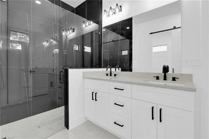 Bathroom featuring double vanity and a stall shower