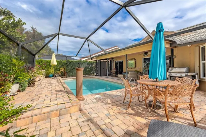 View of swimming pool with ceiling fan, a patio, grilling area, and a lanai