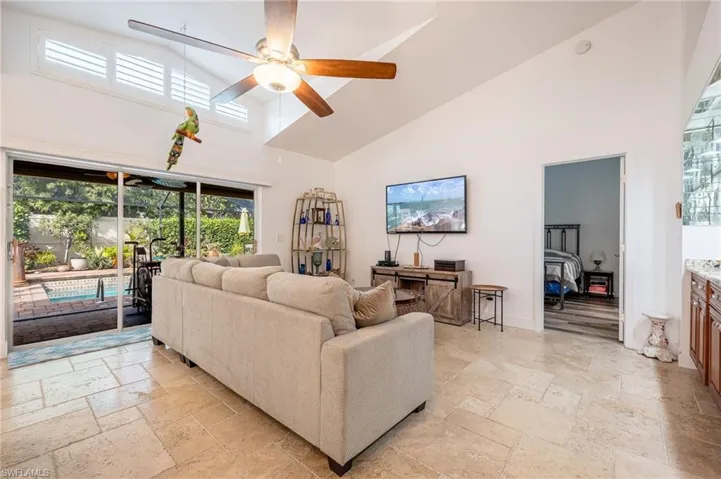 Living room featuring ceiling fan and high vaulted ceiling