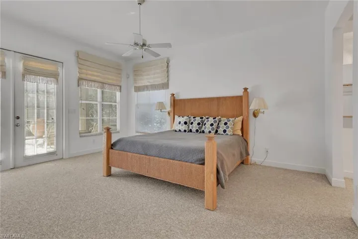 Bedroom featuring light carpet, access to exterior, and ceiling fan