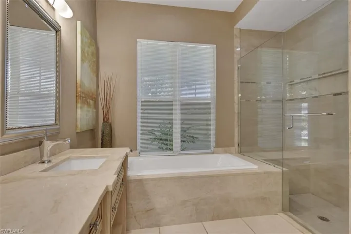 Bathroom with vanity, a bath, a shower stall, and light tile patterned flooring