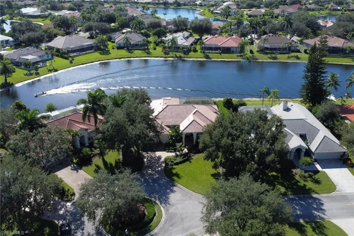 Aerial view of property's location featuring a nearby body of water and nearby suburban area