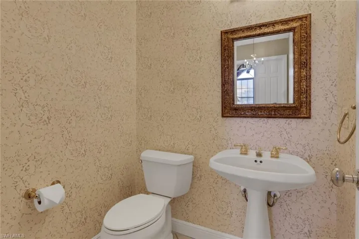 Half bathroom featuring toilet and baseboards