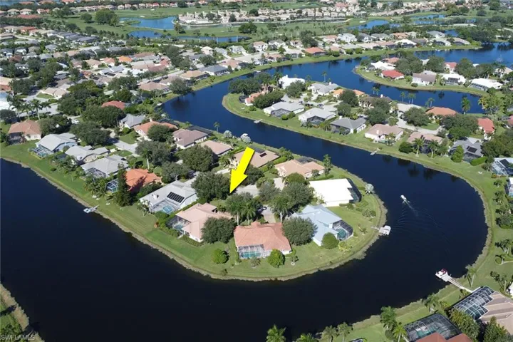 Aerial view of property's location featuring a nearby body of water and nearby suburban area