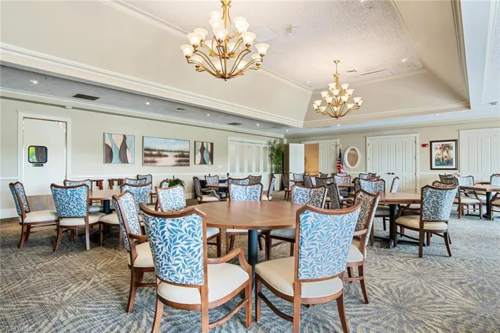 Dining area with carpet flooring, a chandelier, crown molding, and a tray ceiling