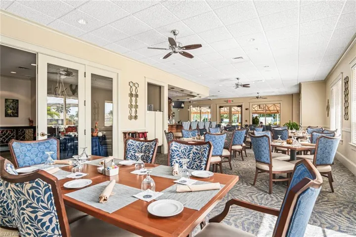 Carpeted dining area with a ceiling fan, healthy amount of natural light, and a drop ceiling