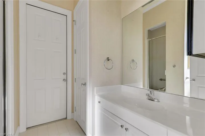 Bathroom featuring vanity, a stall shower, a closet, and light tile patterned floors