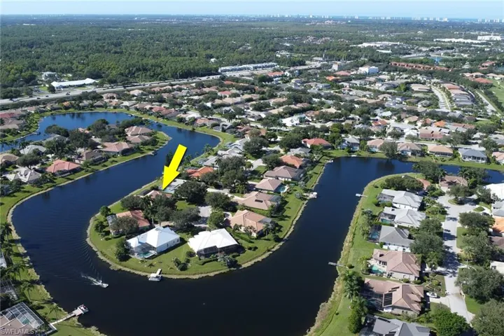 Aerial view of property and surrounding area featuring a large body of water and nearby suburban area
