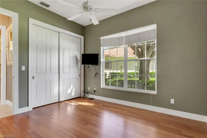 Unfurnished bedroom with wood finished floors, a closet, and a ceiling fan