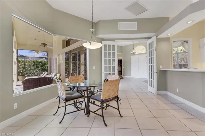 Dining room featuring french doors, light tile patterned floors, and a chandelier