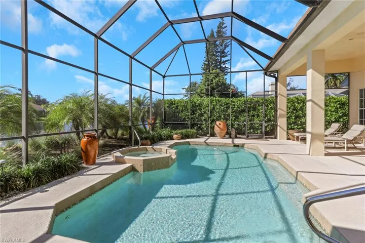 View of pool with a sunroom, glass enclosure, a patio area, and a pool with connected hot tub