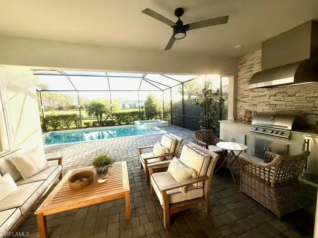 Outdoor pool with an outdoor hangout area, area for grilling, a patio area, and a sunroom
