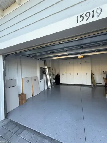 Garage with electric panel and freestanding refrigerator