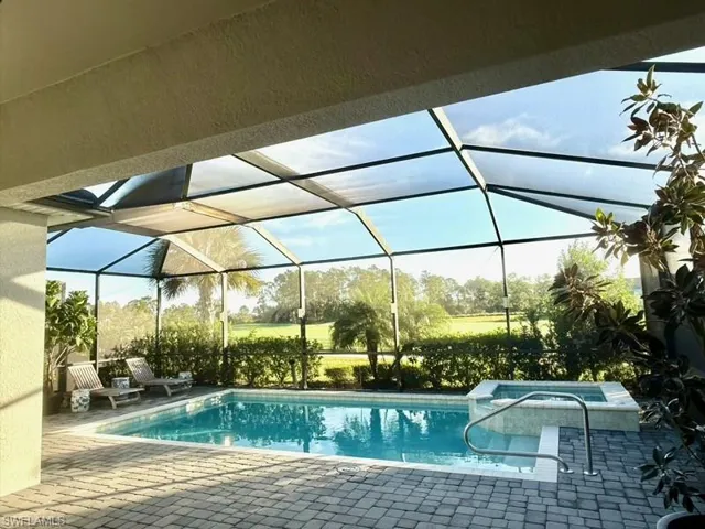 View of swimming pool with a lanai, a sunroom, a patio, and a pool with connected hot tub