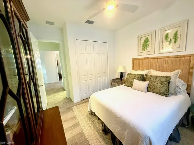 Bedroom with wood finish floors, a closet, and ceiling fan