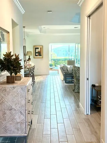 Corridor with ornamental molding and wood finish floors