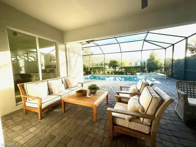 View of patio / terrace featuring outdoor lounge area, an outdoor pool, a sunroom, and glass enclosure