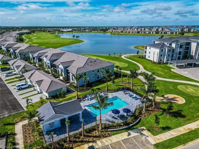 Drone / aerial view of a nearby body of water and a golf course