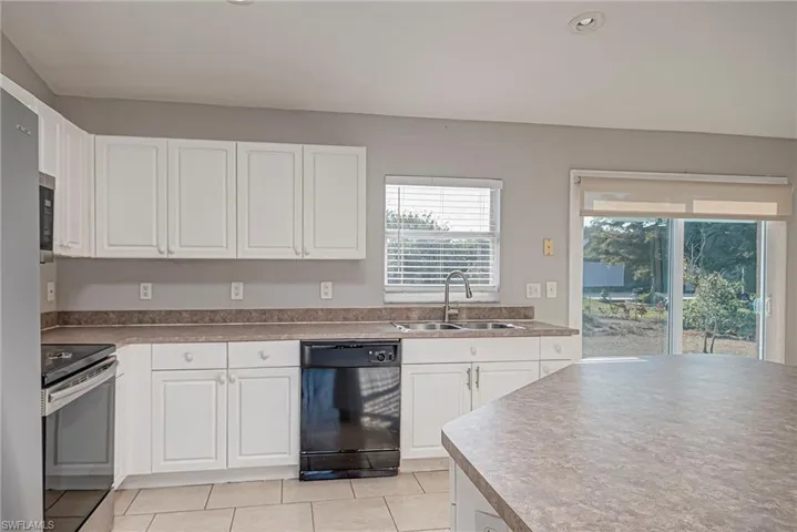 Kitchen featuring white cabinetry, stainless steel appliances, and light tile patterned floors