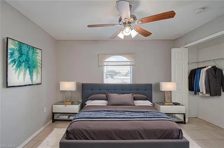 Bedroom with a closet, a ceiling fan, and tile patterned floors