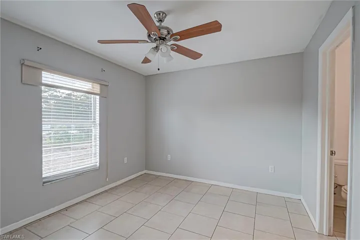 Spare room with ceiling fan and baseboards