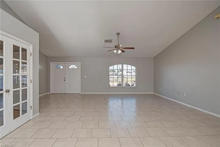 Foyer entrance with ceiling fan, vaulted ceiling, french doors, and light tile patterned floors