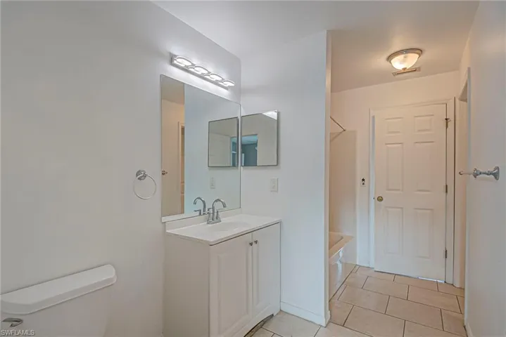 Bathroom with vanity,  shower combination, and light tile patterned floors