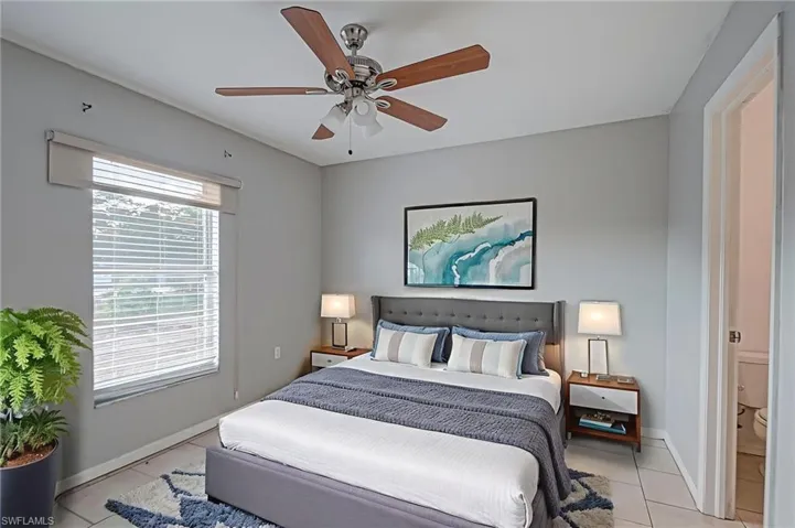 Tiled bedroom featuring baseboards and a ceiling fan