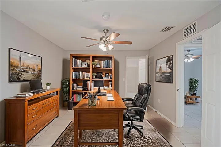 Home office with ceiling fan and light tile patterned floors