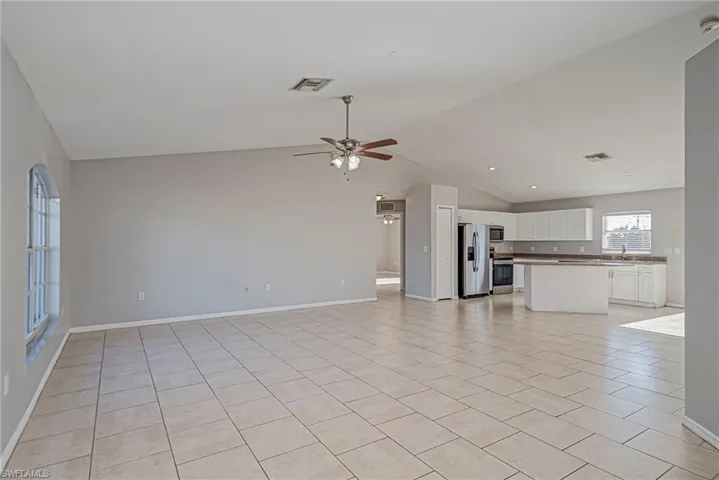 Unfurnished living room with light tile patterned floors and a ceiling fan